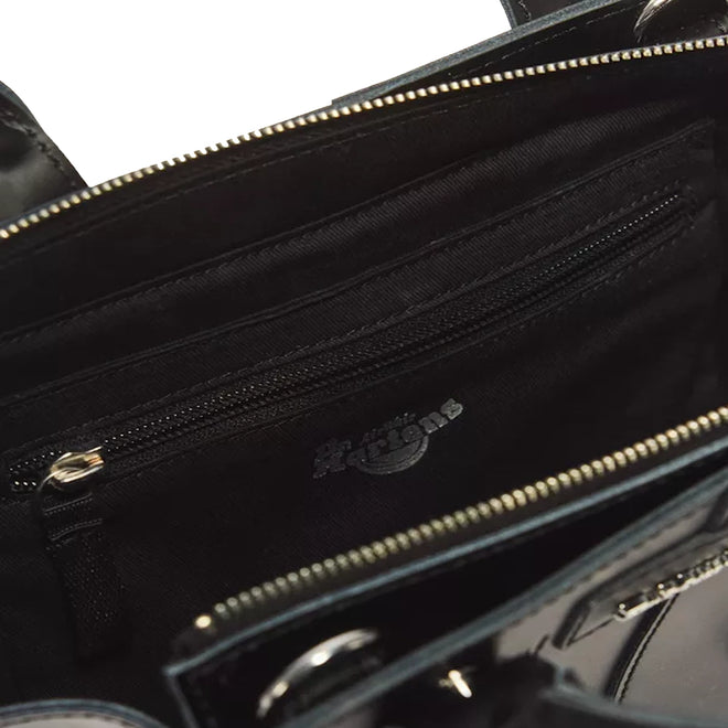 Close-up of the Dr Martens Small Keiv Leather Tote Bag in black, crafted from premium Keiv leather. The bag features a zippered inner pocket and is finished with sleek patent Lamper straps. The zipper and fabric details are clearly visible inside the bag.
