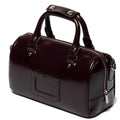 A glossy cherry red leather handbag, the Dr Martens Top Handle Bag in Oxford Rub Off, takes inspiration from classic Dr Martens styling and features two sturdy handles, silver hardware, a front pocket, and a top zip closure.