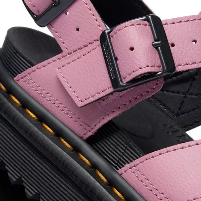 Close-up of the Dr Martens - Voss II Cross Strap Sandal in Dusty Rose Pink, showing a black buckle, thick black sole with yellow stitching, and detailed leather texture with visible tread., 50439, 190665777529, 190665777536, 190665777543, 190665777567, 50444, 50445
