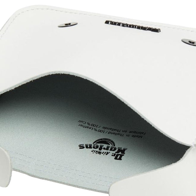 Close-up view of the Dr Martens Leather Cross Body White Leather Box Satchel interior, highlighting the brand logo, detailed stitching, and metal snaps against a light lining., 190665390384
