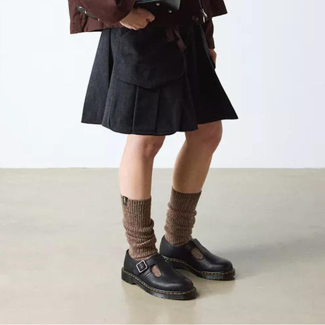 Person wearing a black skirt, brown knee-high socks, and black Dr Martens Polley T Bar  shoes on a plain background.,
190665740530,
190665740547,
190665740561,