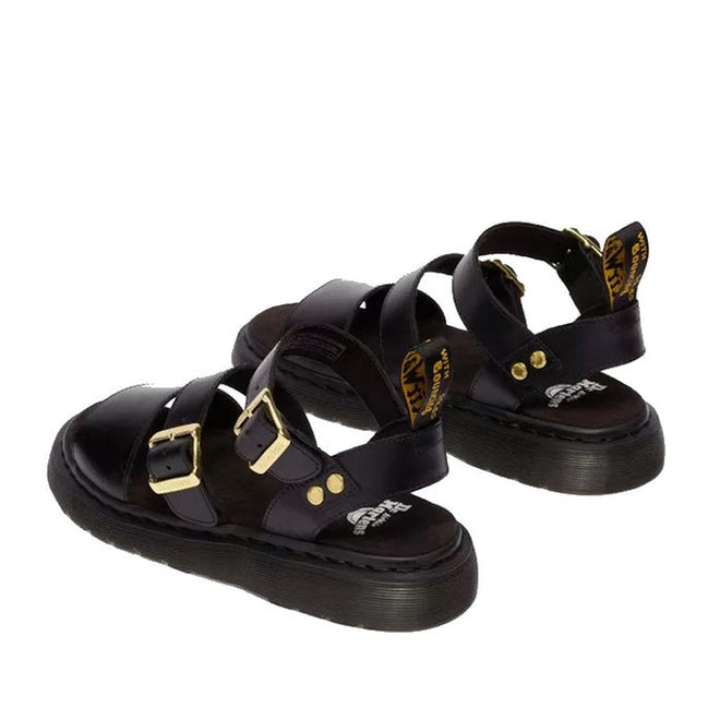 The Dr Martens Gryphon Sandal Black Atlas Leather features thick Goodyear welted soles, gold buckles, ankle straps, and yellow logo heel tags, shown from a rear side angle., 190665783414, 190665783421, 190665783438, 190665783452, 190665783469, 50536