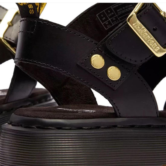 Close-up of Dr Martens Gryphon Sandal Black Atlas Leather with gold-tone buckles and rivets, thick ridged sole, Goodyear welted construction, and branded tag., 190665783414, 190665783421, 190665783438, 190665783452, 190665783469, 50536