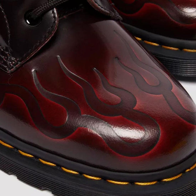 Close-up of the toe of the right foot of  a red leather Dr Martens 1460 boot with embossed flame design  a white background,
190665743081,
190665743098,
190665743104,
190665743128,
190665743135,
190665743142,
190665743166,