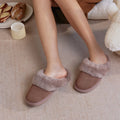 Wearing EMU Women's Jolie Mocha Slipper Scuff Sheepskin, a person’s legs and feet rest on a beige carpet. Fluffy cuffs and mocha suede highlight these women’s indoor outdoor slippers. Nearby are pastries on a plate and a yellow mug., 51650, 9330071975503, 9330071975510, 9330071975527, 9330071975534, 51655