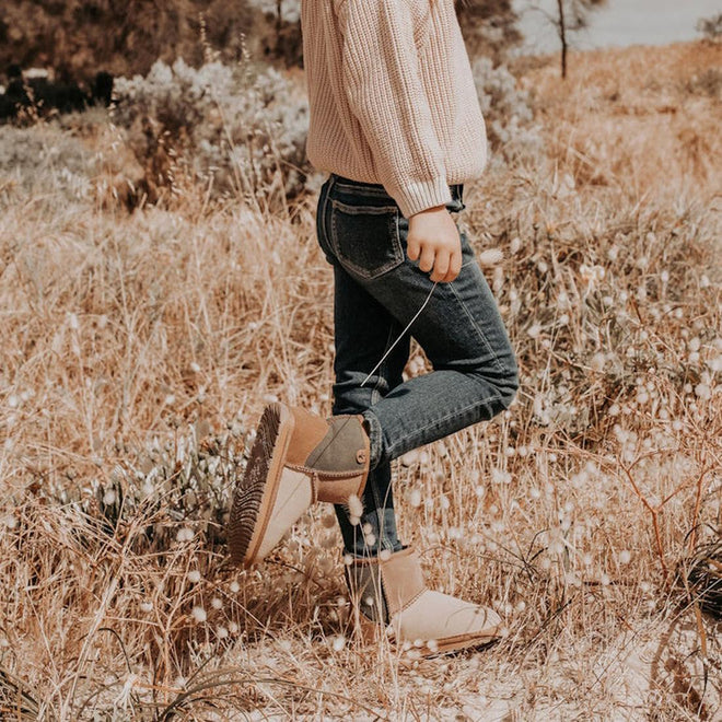 A chile wearingr the EMU Wallaby mini outdoors, featuring a patchwork design with chestnut, green, beige, and brown colors, made from merino wool and suede materials.,
9330071960721,
9330071960738,
9330071960745,
9330071960752,
9330071960769,
9330071960776,
9330071960783,