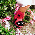 A child in pink pants wears EMU Kids Creatures Red Ladybird Wool Boots, known for comfort and durability, standing among vibrant pink and white flowers., 51426, 9330071131183, 9330071131190, 9330071131206, 9330071131213, 9330071131220, 9330071131237, 9330071131244, 9330071131251, 9330071131268