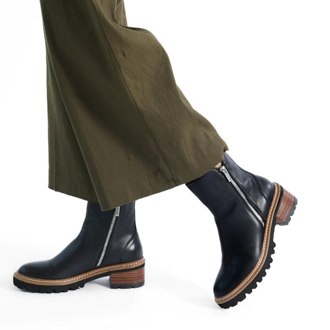 9321191195285,
9321191195292,
9321191195308,
9321191195315,
9321191195322,
9321191195339,
9321191195346,
women walking wearing EOS Lindira women’s boot in black leather, with side zip and wood-look heel. Right Foot Outside of leg view from the front. And the inside of the foot on left side.