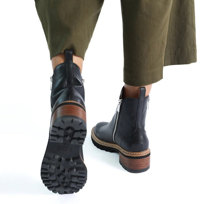 9321191195285,
9321191195292,
9321191195308,
9321191195315,
9321191195322,
9321191195339,
9321191195346,
A womean walking away from te camera showing the heels of EOS Lindira women’s boot in black leather, with side zip and wood-look heel. 