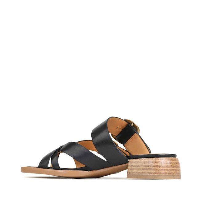 The EOS Teia Black Low Heeled Sandal Slide features crisscross cashmere leather straps, an open toe, ankle buckle strap, and a low stacked wooden heel, shown from the side against a white background., 9321191143897, 9321191143903, 9321191143910, 33736, 9321191143934