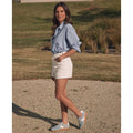 Outdoors on a gravel path, a woman in a blue striped shirt and white shorts faces the camera with one hand in her pocket, wearing EOS Melbaa Sky Suede Leather Lace Up Trainers; grassy lawn and shrubs are visible behind her., 41698, 9321191224558, 9321191224565, 9321191224572, 9321191224589, 9321191224596, 41704