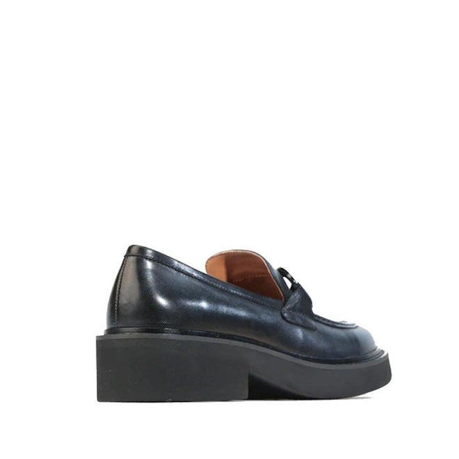 The EOS Womens Leia Loafer Slip In Black Leather, featuring a chunky cleated heel and smooth finish, is shown from a rear side angle against a white background., 50596, 9321190036855, 9321190036862, 9321190036879, 9321190036886, 9321190036893, 50602