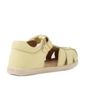The Bobux IWalk Holly Toddlers Sandal in Wax Yellow, featuring a closed toe, closed heel, Velcro strap, open sides, and quick-drying leather construction, is displayed from a rear side angle on a white background.