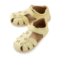 A pair of Bobux IWalk Holly Toddlers Sandal Wax Yellow Closed Toe, featuring quick-drying light yellow leather with flower-shaped cutouts and a Velcro ankle strap, displayed on a white background.