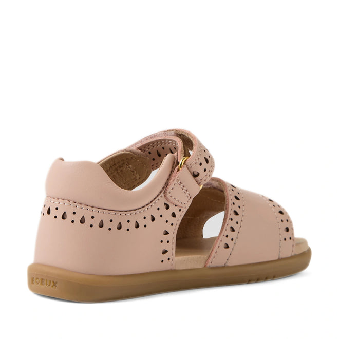 The Bobux IWalk Logan Toddlers Sandal in Cameo Rose Pink features soft leather with a closed heel, delicate cutout patterns, a convenient Velcro strap, and a tan rubber sole, shown from the back at an angle.