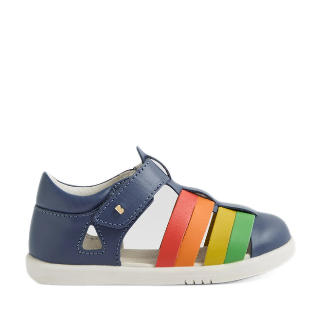 A side view of the Bobux IWalk Tidal Sandal in Multi Vintage Indigo for toddlers, featuring a blue water-friendly leather upper, a white sole, and vibrant straps in red, orange, yellow, and green. These closed-toe sandals are designed to protect little feet while ensuring durability for playful adventures., 9420074807854, 9420074807861, 9420074807878, 9420074807885, 9420074807892
