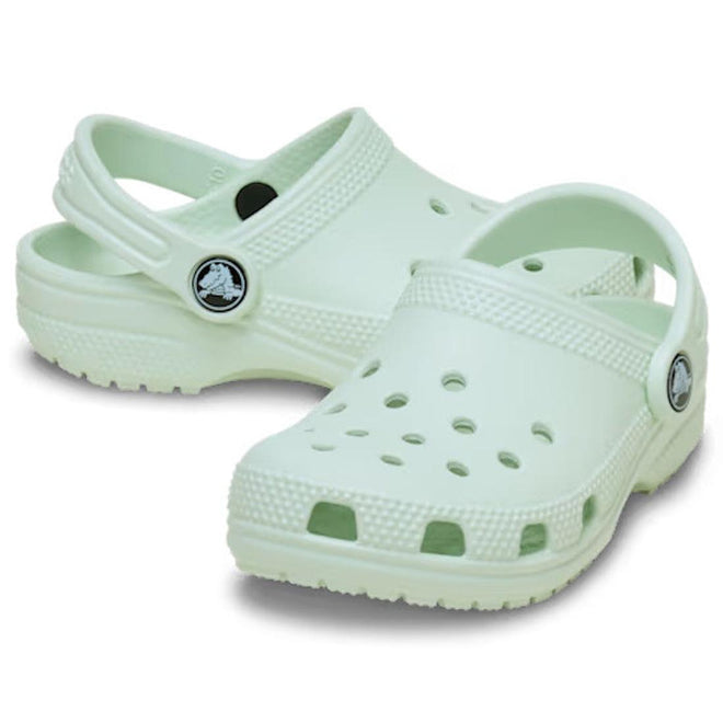 A pair toddlers Crocs Classic Clog Sandal of light green clogs on a white background