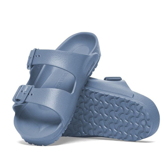 a pair of Birkenstock Kids EVA Elemental Blue Arizona Sandal Narrow Width with double straps, one over the foot and one over the toes with buckle adjustment. Staps are linked at the sides of the foot. Made of EVA a plastic like material, suitable fot being around water