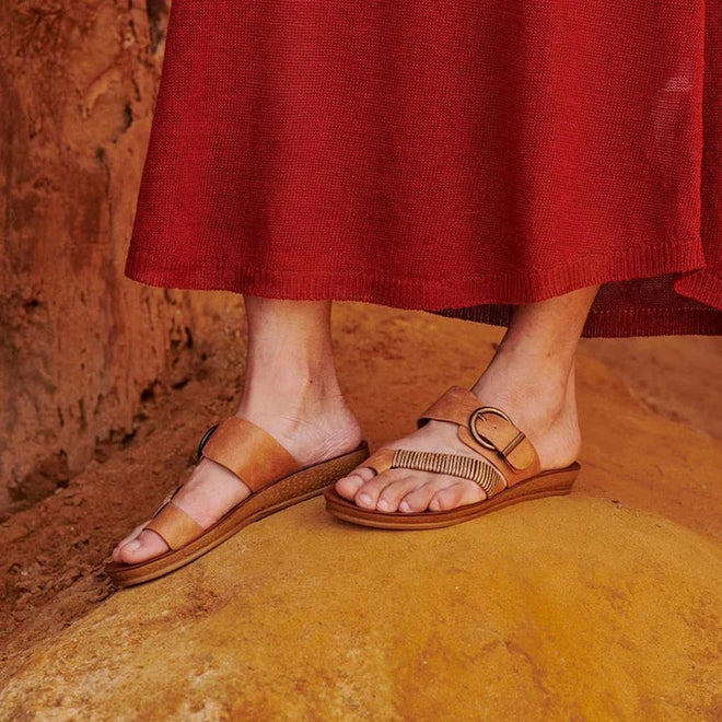 Los Cabos Bria Brandy on feet showing the right foot top view of teh sandal with the toe prong, cross strap with faux woven bamboo and the buckle adjustable strap over the top of the foot. Shows the left foot inside view of  toe prong and over the top of the foot strap
