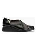 A Pitillos black patent leather shoe with elastic over the top of the foot and a wedge heel.