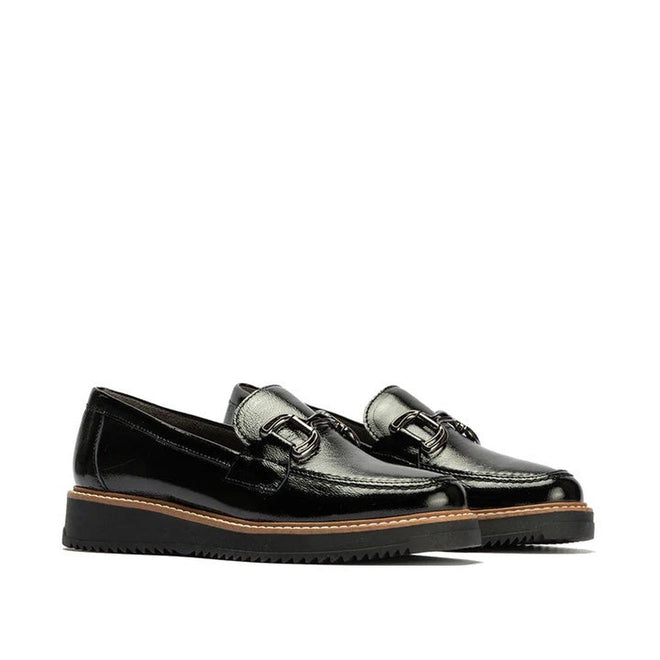 The Pitillos Womens Black Patent Slip On Loafer 10760 features metallic buckles, thick ridged black soles, and a brown trim around the base. Displayed against a plain white background.,8445191661319, 8445191661326, 8445191661333, 8445191661340, 8445191661357, 51930