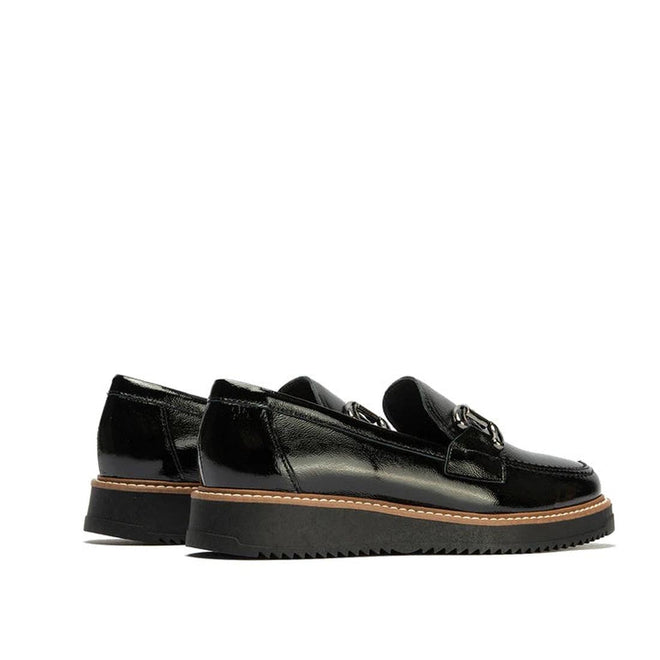 The Pitillos Womens Black Patent Slip On Loafer 10760 features chunky ridged soles, brown stitching, and metal detailing for a modern yet comfortable look—shown here against a white background., 8445191661319, 8445191661326, 8445191661333, 8445191661340, 8445191661357, 51930