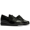The Pitillos Womens Lycra and Patent Leather Shoe 10731 features black uppers with subtle wave patterns, glossy patent leather toe caps and heels, a removable insole, and wedge soles, shown against a white background.