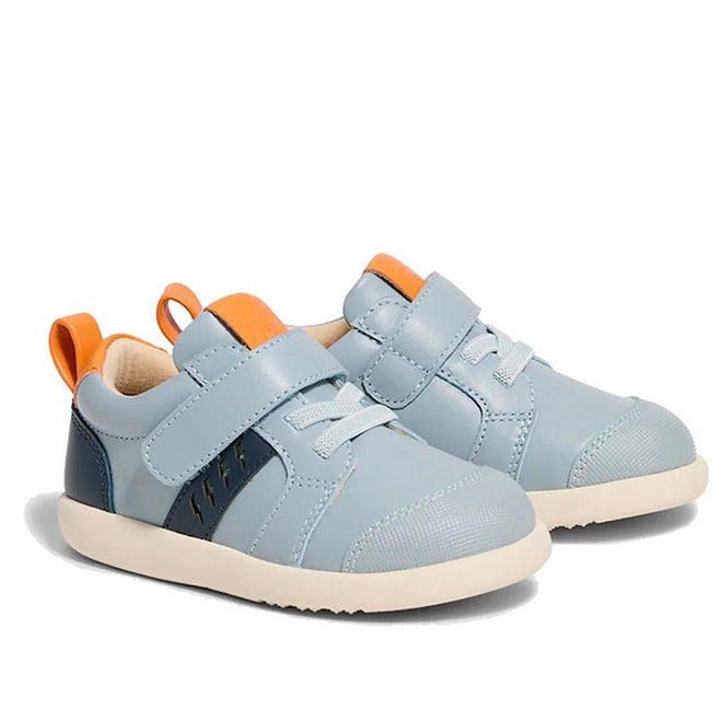 The Pretty Brave SID Leather Trainer First Walker Indigo Blue Grey features light blue leather, white soles, orange pull tabs, dark blue side panels, and hook-and-loop straps—podiatrist approved shoes ideal for early walkers., 9420075362918, 9420075362901, 9420075362895, 9420075362888