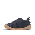 The Pretty Brave First Walker Toto Leather Trainer in Indigo Blue is a flexible baby shoe with two hook-and-loop straps, tan rubber sole, visible stitching, and a black heel pull tab—perfect for first walkers. Displayed on a white background., 9420075366275, 9420075366268, 9420075366251, 50971