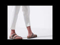A womens wear white 3 quater pants walking waering mocha brown Birkenstock Mayari sandals with the toe loop and buckle adjustemnt over the foot. On a white background