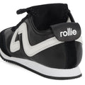 A close-up of the Rollie Womens Shift Black/Bone Sneaker, showing the back and side with a white zigzag design, black heel tab displaying "rollie" in white lettering, and a white sole with a black bottom., 9339554369945, 9339554362427, 9339554100234, 9339554006246, 9339554000138