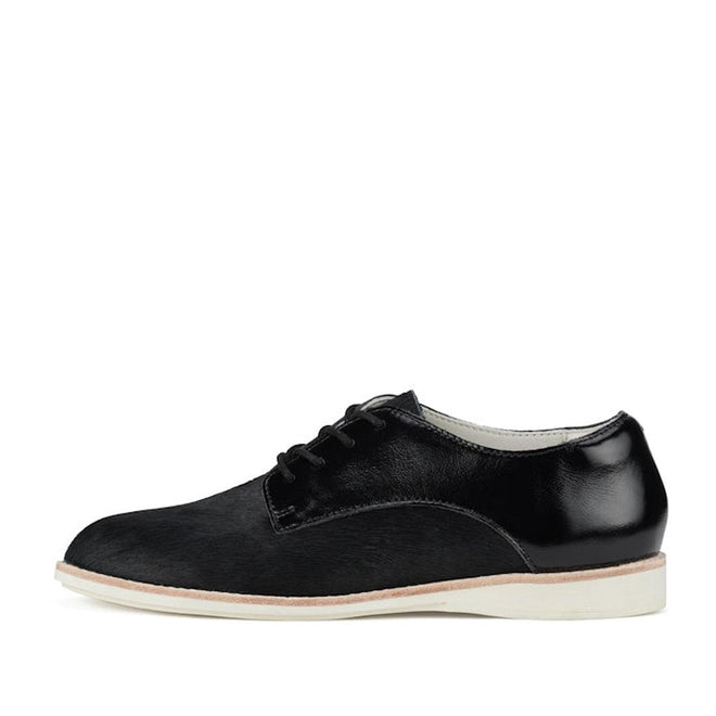 The Rollie Womens Derby Black Splice Leather Brogue Shoe is a black leather oxford with a white sole, black laces, and polished finish, featuring an orthotic-friendly removable footbed, shown in a side view on a white background., 51190, 9339554014920, 9339554054292, 9339554007458, 9339554000329, 9339554389769