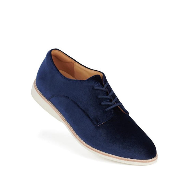 The Rollie Womens Derby Navy Velvet Brouge Shoe is a single navy blue velvet lace-up dress shoe with a tan interior lining and a white sole, displayed against a plain white background.