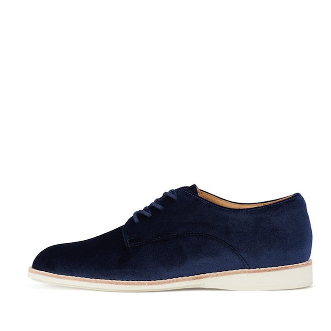 The Rollie Womens Derby Navy Velvet Brouge Shoe features a rounded toe, navy velvet finish, and flat off-white sole, shown in side profile against a white background., 9339554000046, 9339554035741, 9339554028743, 9339554006123, 9339554009810
