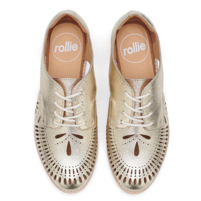 Top view of the Rollie Womens Sidecut Boho Punch Gold Leather Shoe: gold brogue lace-ups with decorative cutouts, white soles, comfy memory foam footbed, and tan insoles branded “rollie” in white., 9381760798811, 9381760798828, 9381760798835, 9381760798842, 9381760798859