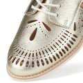 Close-up of the toe of the Rollie Womens Sidecut Boho Punch Gold Leather Shoe, featuring white laces, intricate cutout patterns revealing light brown underlays, and a memory foam footbed for all-day comfort in Boho style., 9381760798811, 9381760798828, 9381760798835, 9381760798842, 9381760798859