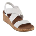 The Skechers Womens Arch Fit Beverlee Love Stays White Wedge Sandal features white woven crisscross straps, a cork platform heel, a brown memory foam footbed, and an open-toe design with a supportive slingback strap.