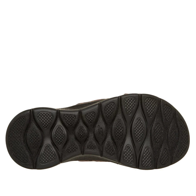 The image shows the black rubber sole of the Skechers GO WALK Flex Sandal Kat Slide Black Leopard, featuring a textured pattern with oval and diamond-shaped treads for enhanced grip and traction.