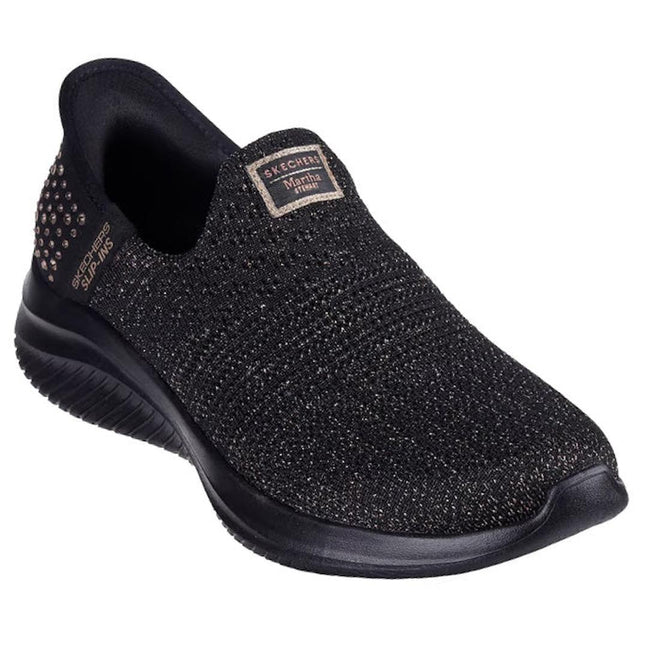 Font and side view of a Skeckers Slip In Glam Life Martha Stewart Black slip-on shoe with brand logo on a white background, right foot front side view,