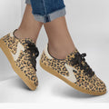 A person in rolled-up blue jeans and Skechers Womens HotShot On The Prowl Leopard Suede Sneakers with beige soles, black laces, and Air-Cooled Memory Foam stands against a plain light background., 52252, 199025014359, 199025014373, 199025014380, 199025014397, 199025014410, 52257