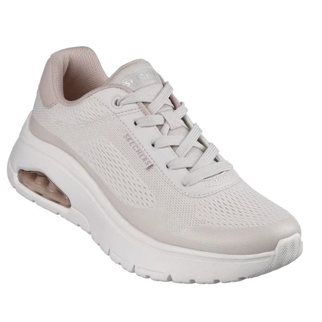The Skechers Womens Uno Flex Spring On Air Taupe Trainer is a light beige sneaker with a thick white sole, visible air-cushioned heel, mesh upper, laces, subtle side and tongue branding, and a comfortable Memory Foam insole.