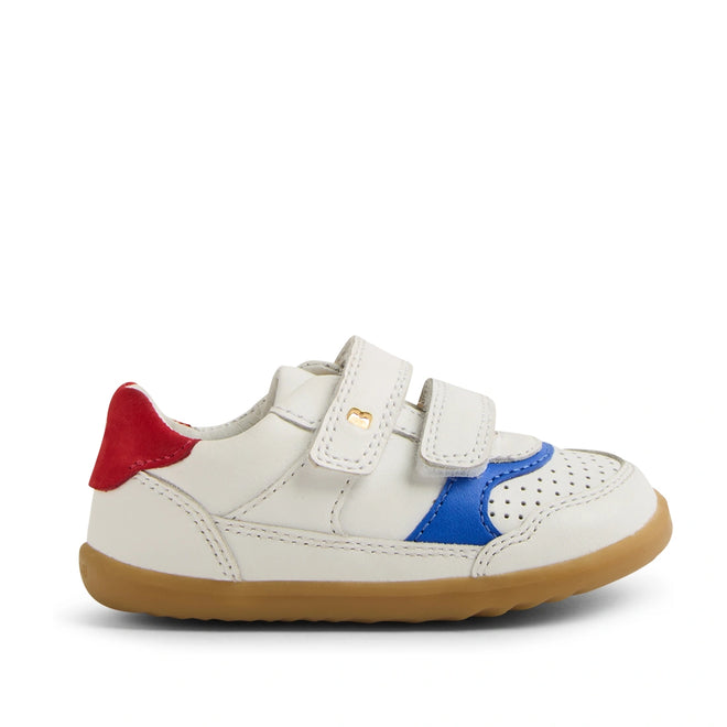 The Bobux SU Step Up Hunter Leather Toddlers Sneaker in White Salsa features a small white leather design for kids, with red, blue, and tan accents, two hook-and-loop straps, a perforated toe, and a tan rubber sole. The sneaker is displayed from the side on a white background.