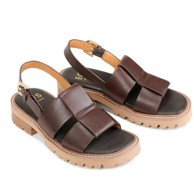 The EOS Womens Leonella Dark Brown Sandal with Back Strap features wide crisscross straps, tan ankle buckles, and thick tan rubber soles with ridged treads, displayed on a white background., 40427, 9321191223438, 9321191223445, 9321191223452, 9321191223469, 9321191223476, 40433
