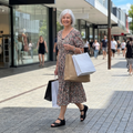 Woman in a floral dress with shopping bags on a city street weaing Ziear Daffodil Sandals Shoes with a aclised back for heel support.,  49107, 49108, 9355342051830, 9355342051687, 9355342051694, 9355342051700, 49113