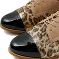 Close-up of the Ziera Tobin XF Women's Flat Brogue in Black Taupe Leopard, showcasing glossy black cap toes, leopard print sides with metallic sheen, tan suede uppers, and a removable comfort plus footbed on a white background., 51040, 4434755462978, 4434755462985, 4434755462992, 4434755463005, 4434755463012, 4434755463029