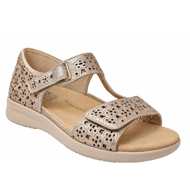 Ziera Bizza Pale Gold XW Women’s Leather Sandal features an open-toe design in pale gold leather with perforated floral patterns, an adjustable Velcro front strap, and a buckle-fastened ankle strap. With an extra wide fit, low beige sole, and cushioned insole, these sandals offer comfort and support for all-day wear.