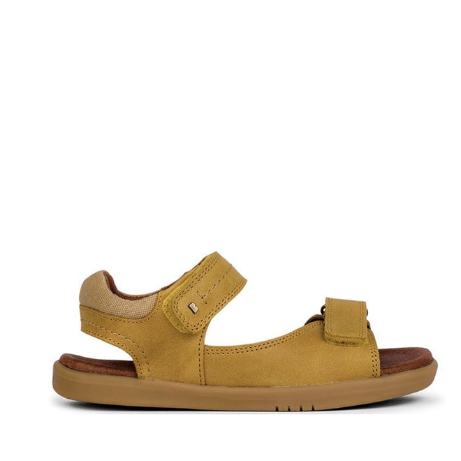 The Bobux Kid+ Plus Driftwood Chartreuse Open Toe Sandal 833507 features a tan and brown adjustable strap, two Velcro closures (ankle and toe), a flat rubber sole, and is photographed on a white background—ideal comfy leather sandals for kids’ adventures., 9420062039205, 9420062039212, 9420062039229, 9420062039236, 9420062039250, 9420062039243, 9420062039267