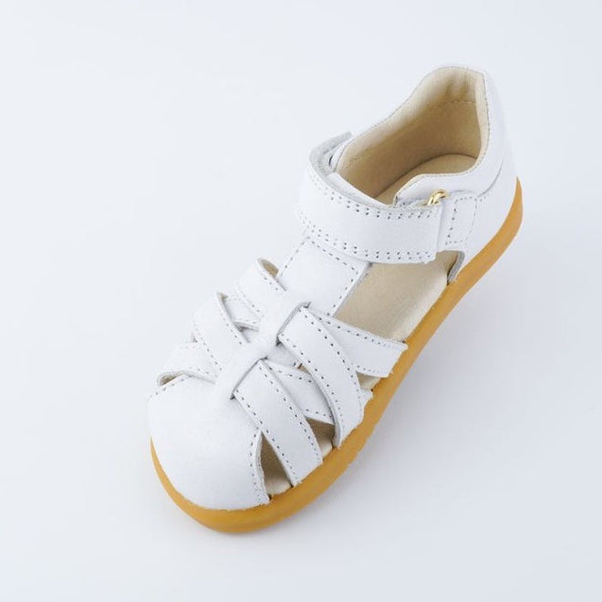 The Bobux iwalk Cross Jump Sandal White Closed Toe 636706 is a children's white leather sandal with a closed toe, Velcro fastening, and tan rubber sole, shown on a plain white background., 9420062083949, 9420062083956, 9420062083963, 9420062083970, 9420062083987