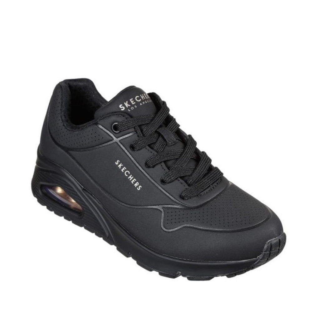 The Skechers Uno Stand On Air WIDE Width Women’s Trainer Black Sole is a black sneaker designed with a thick sole and a visible air cushion at the heel. It features black laces, Air-Cooled Memory Foam for enhanced all-day comfort, and showcases the Skechers logo on both the tongue and side of the shoe.
