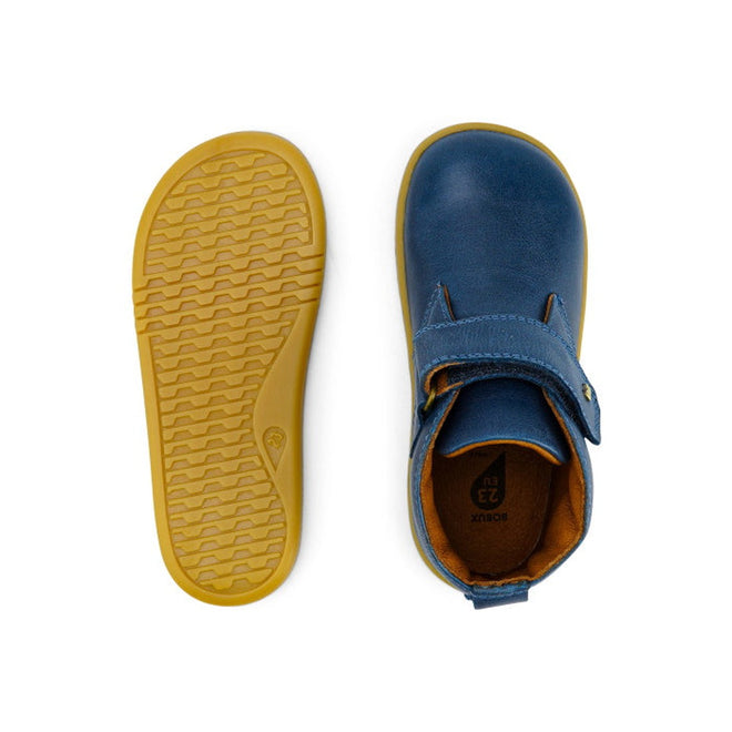 A pair of Bobux Iwalk IW Desert Boot Midnight Blue 625217 children’s shoes, shown with one displaying the wide strap closure from above and the other highlighting the yellow textured rubber sole from below., 9420068516984, 9420068516991, 9420068517004, 9420068517011, 9420068517028